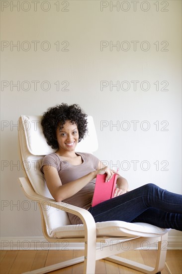 Portrait of young woman sitting in armchair. Photo : Rob Lewine
