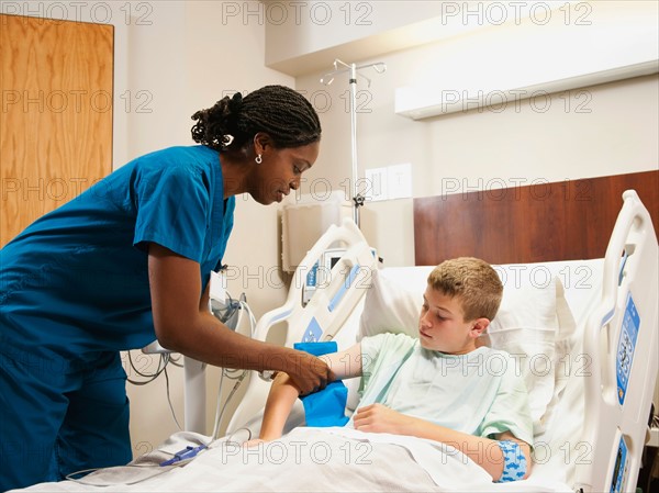 Nurse checking blood pressure to boy (10-11).