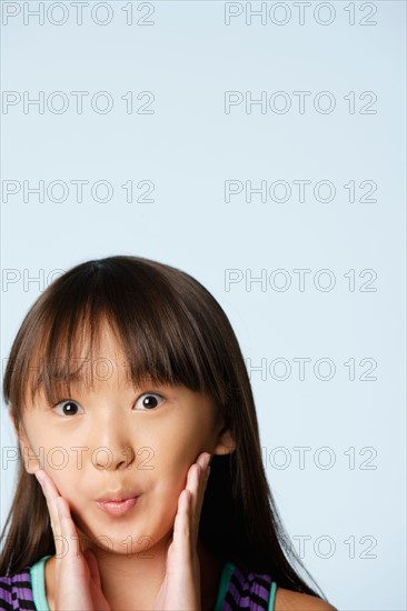 Studio portrait of girl (10-11) raising eyebrows. Photo : Rob Lewine