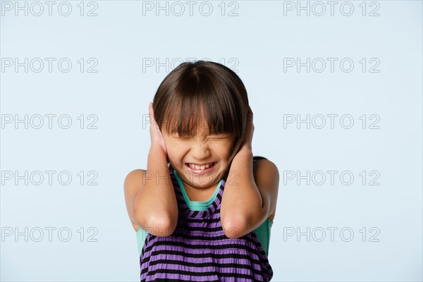 Studio portrait of girl (10-11) with head in hands. Photo : Rob Lewine