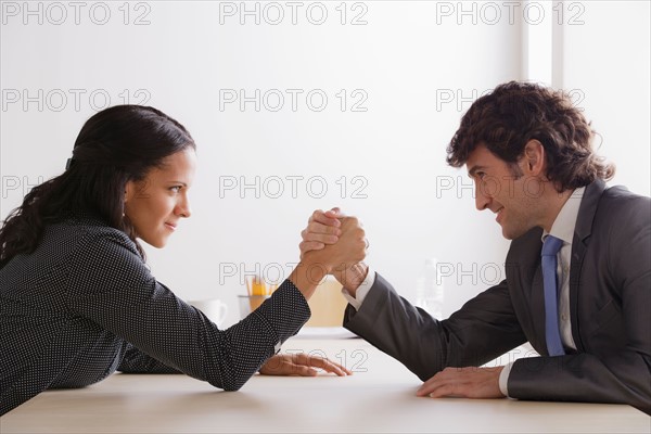 Business man and business woman armwrestling. Photo : Rob Lewine