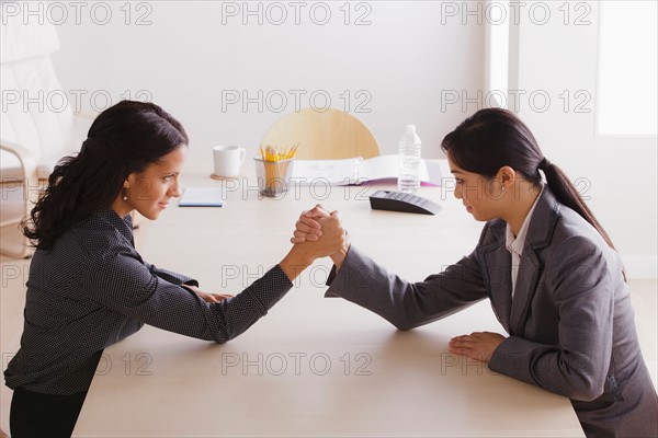 Business man and business woman armwrestling. Photo : Rob Lewine