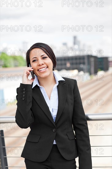 USA, Washington, Seattle, Young businesswoman talking on phone. Photo: Take A Pix Media
