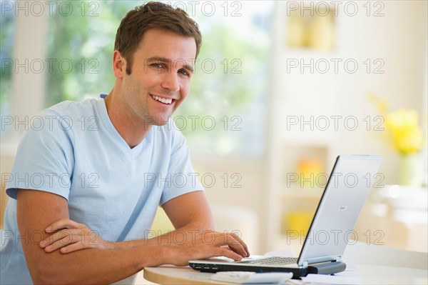 Portrait of young man using laptop.
