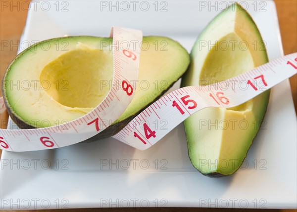 Close up of halves of avocado andMeasuring tape. Photo : Jamie Grill