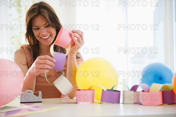 Woman preparing paper chain. Photo : Jamie Grill