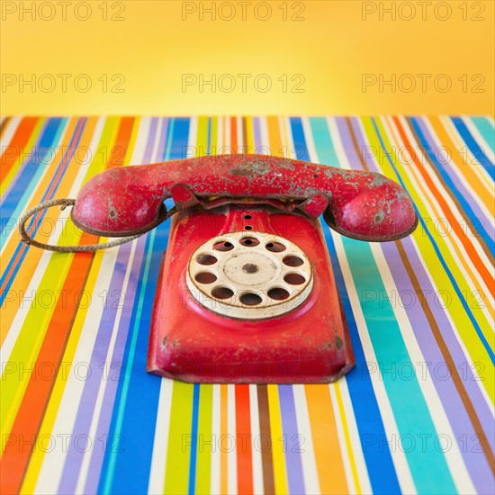 Studio shot of rotary phone on striped background.
