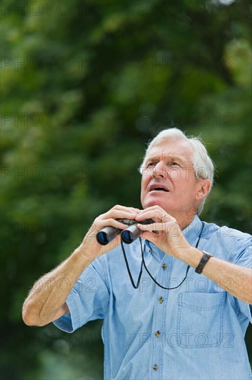 Senior man with binoculars.