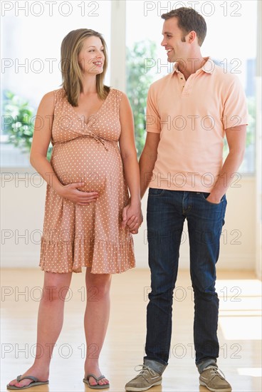 Pregnant woman holding partner's hand.