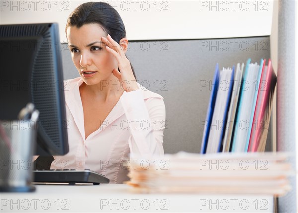 Businesswoman working at desk in office. Photo: Jamie Grill