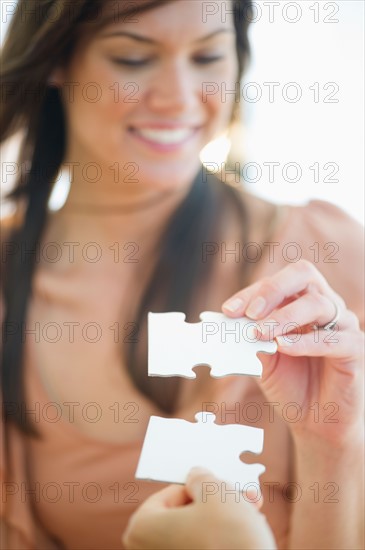 Smiling woman holding jigsaw. Photo : Jamie Grill