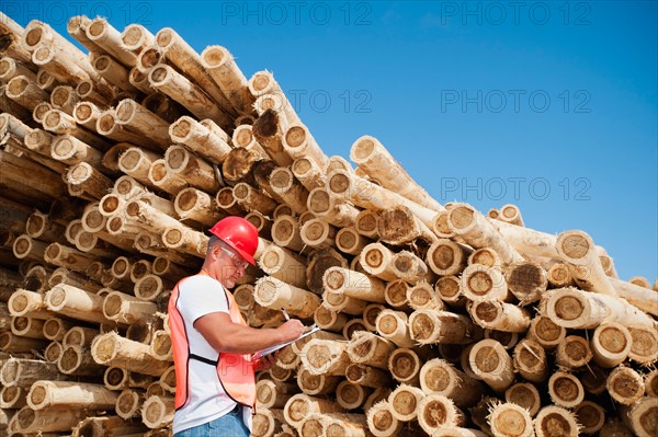 Engineer in front of stack of timber.