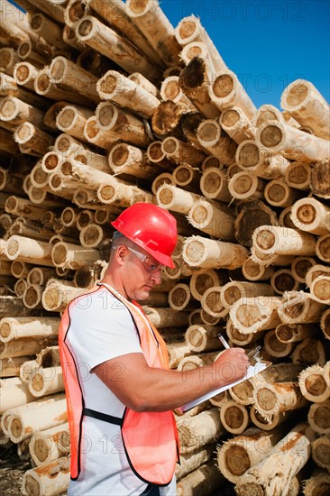 Engineer in front of stack of timber.