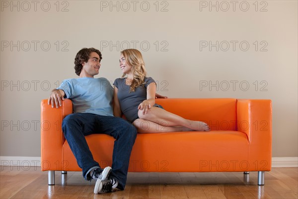 Young couple sitting on sofa. Photo: Rob Lewine