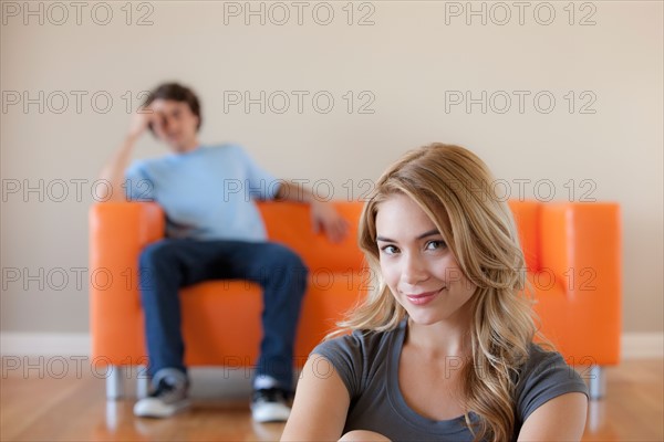 Young couple in room, focus on woman in foreground. Photo : Rob Lewine