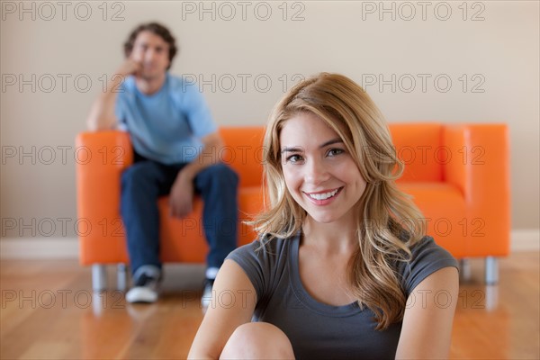 Young couple in room, focus on woman in foreground. Photo : Rob Lewine