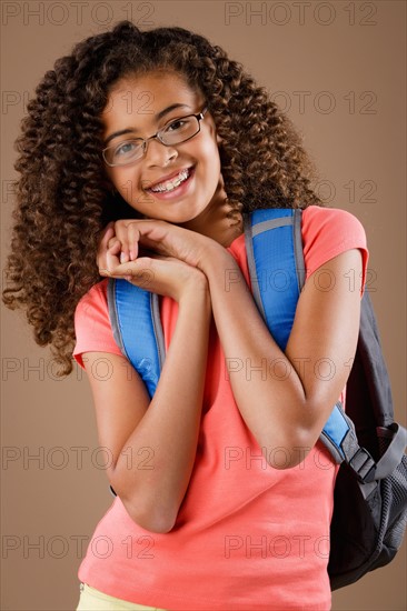 Studio portrait of girl (10-11) wearing backpack. Photo : Rob Lewine