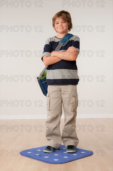 Studio portrait of boy (8-9) carrying backpack. Photo : Rob Lewine