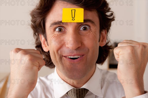 Studio portrait of businessman with adhesive note on forehead. Photo : Rob Lewine