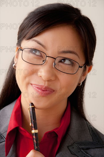 Studio portrait of businesswoman holding pen. Photo : Rob Lewine