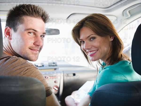 Smiling couple sitting in car. Photo : Jamie Grill