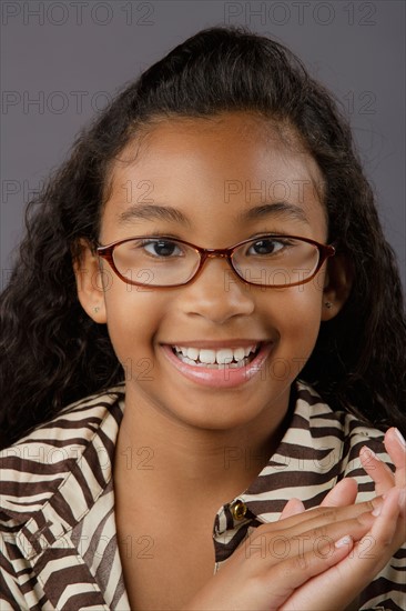 Portrait of smiling girl (8-9), studio shot. Photo : Rob Lewine