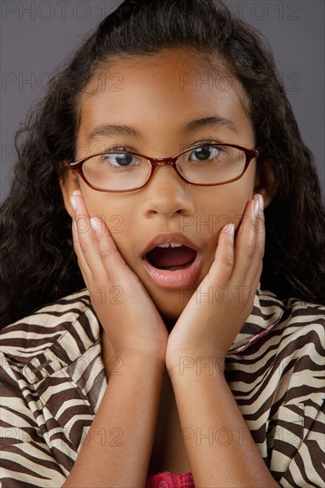 Portrait of surprised girl (8-9), studio shot. Photo : Rob Lewine