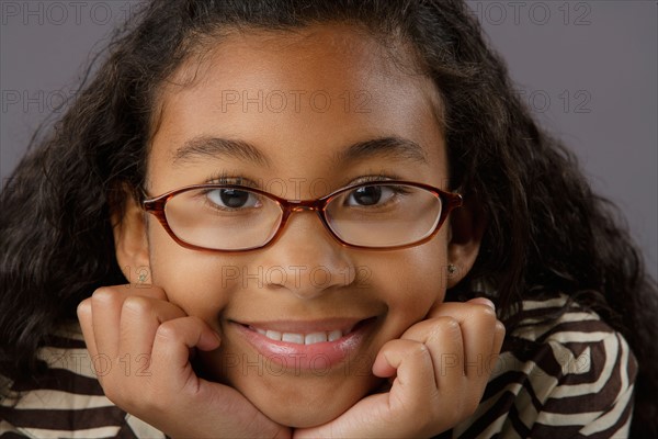 Portrait of smiling girl (8-9), studio shot. Photo: Rob Lewine