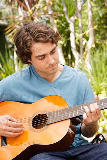 Young man playing guitar. Photo : Rob Lewine