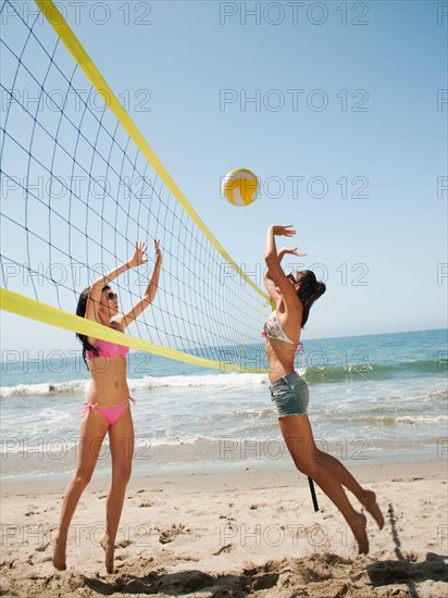 Two attractive young women playing beach volleyball . Photo: Erik Isakson