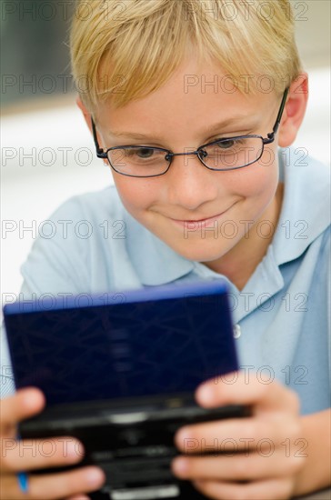 Boy (10-11) playing video game.