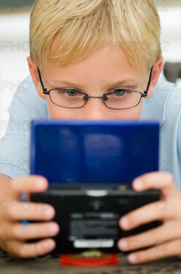 Boy (10-11) playing video game.