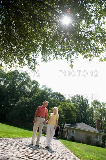 Senior couple walking down footpath.