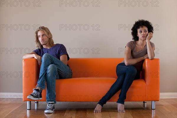 Young couple sitting on sofa. Photo: Rob Lewine