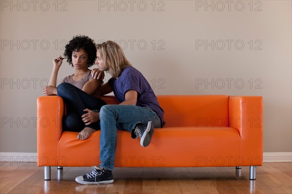 Young couple sitting on sofa. Photo : Rob Lewine