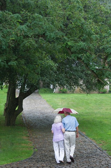Senior couple walking in park.