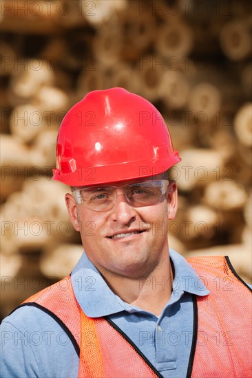 Engineer in front of stack of timber.