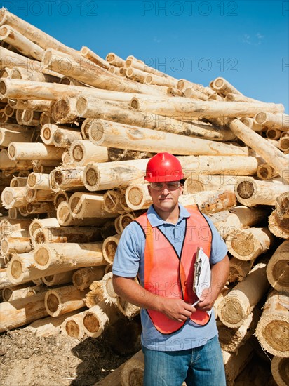 Engineer in front of stack of timber.