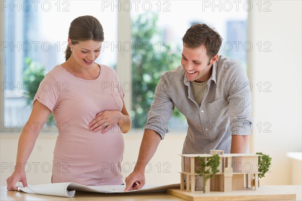 Young couple looking at blueprints.