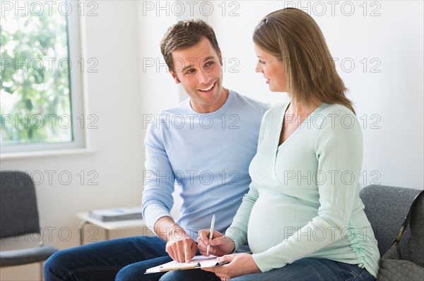 Young couple in doctor's waiting room.