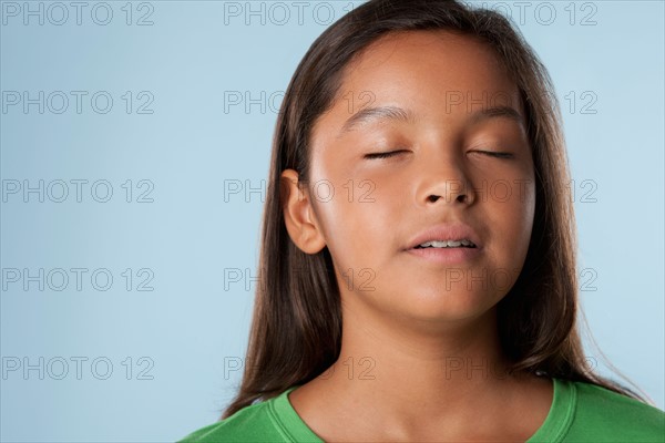 Studio portrait of girl (10-11) with closed eyes. Photo : Rob Lewine