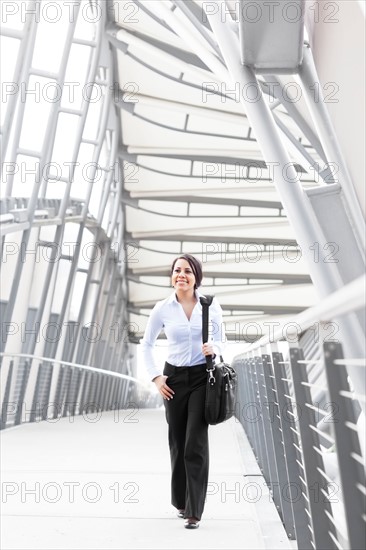 Young businesswoman on walkway. Photo: Take A Pix Media