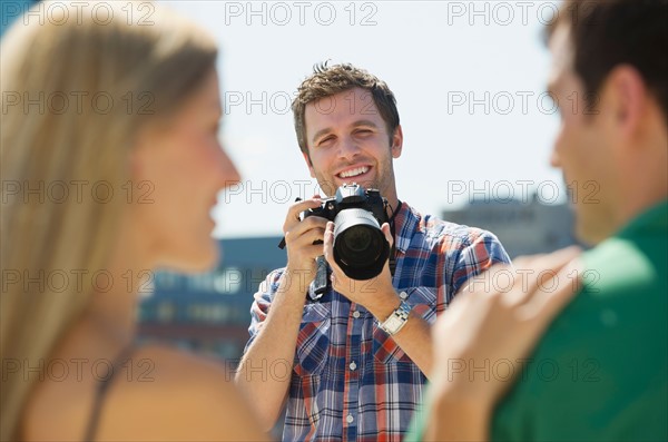 Photographer taking picture of couple.
