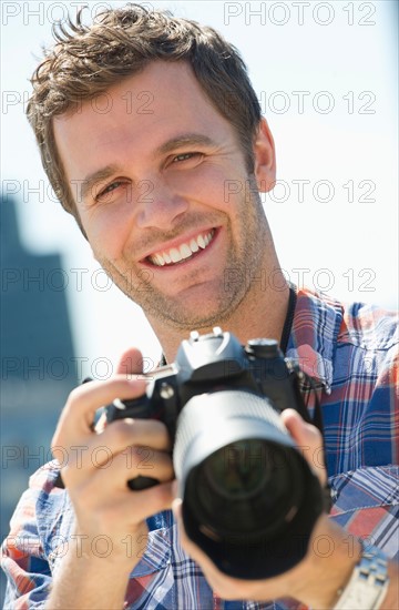 Portrait of man holding camera.