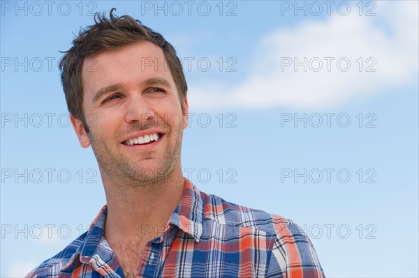 Portrait of mid adult man against blue sky.