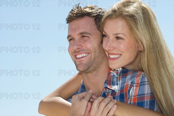 Portrait of mid adult couple against blue sky.