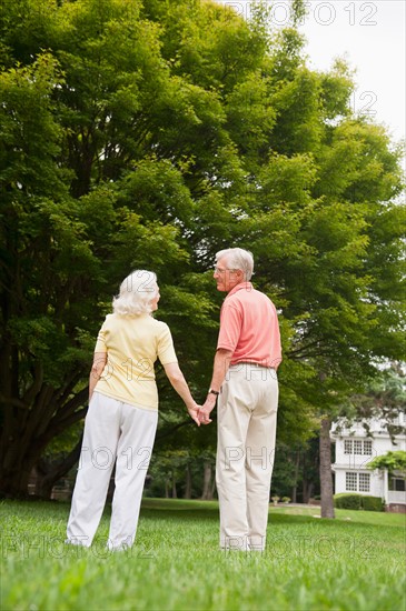 Senior couple standing in park.