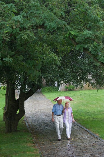 Senior couple walking in park.