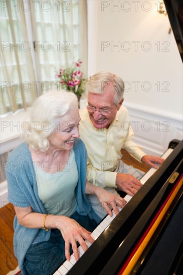 Senior couple playing piano.