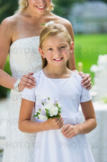 Bride with flower girl (10-11) at wedding reception.